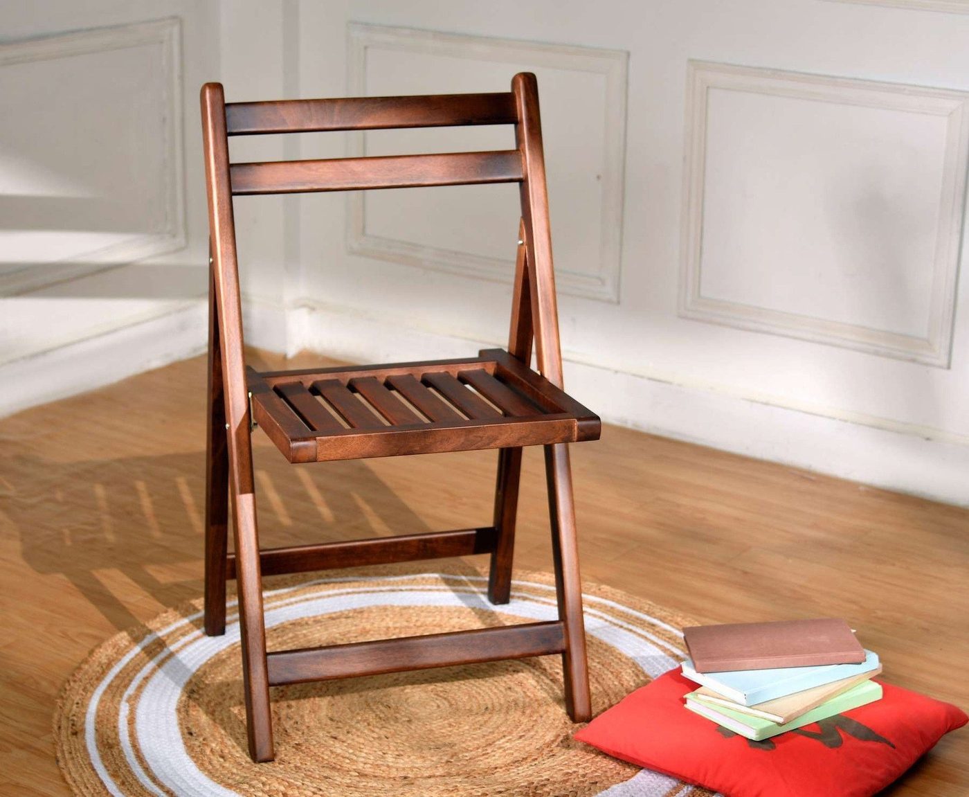 Folding chair in a room beside a stack of books