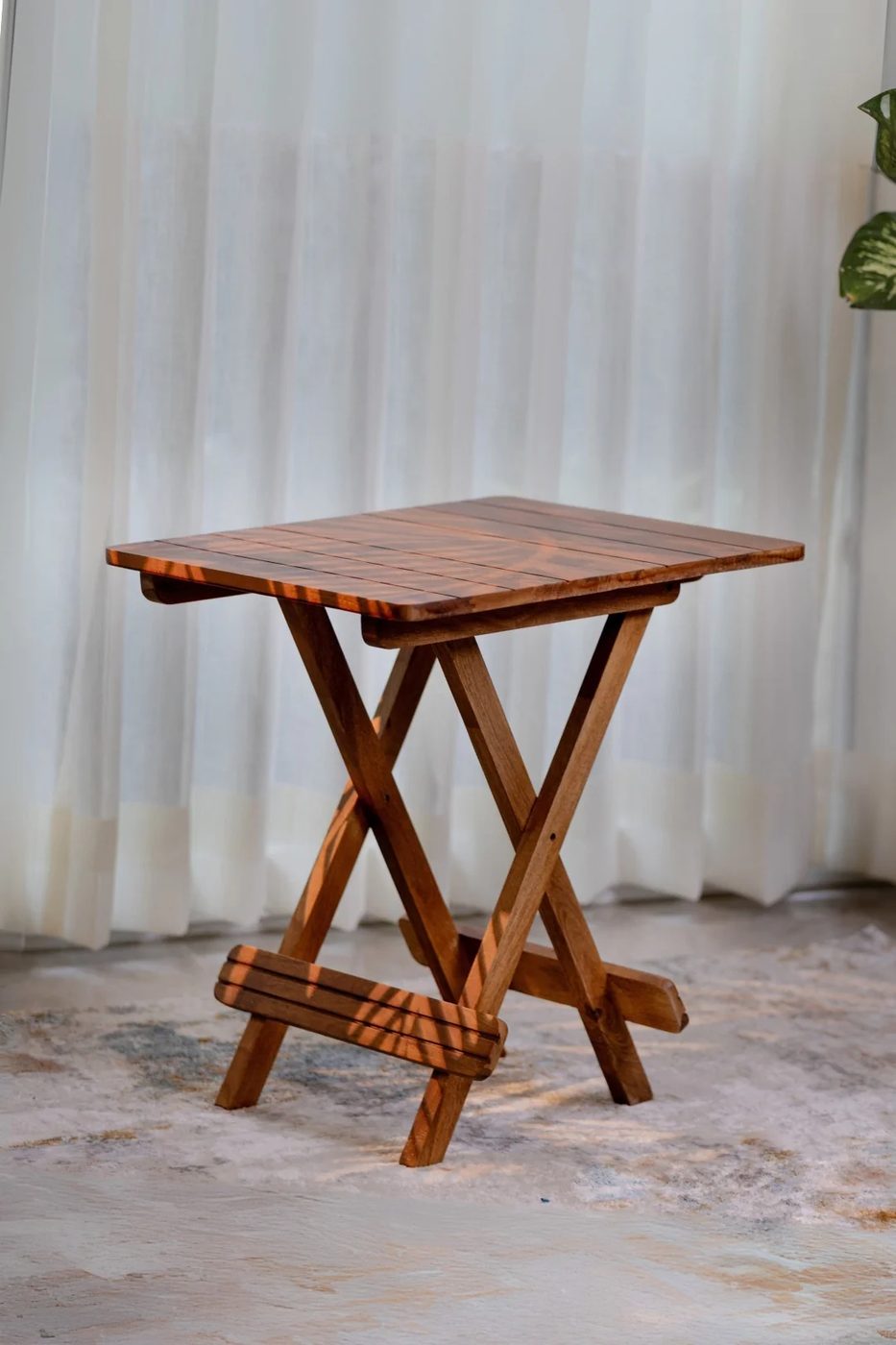 Honey-finish folding side table against a curtained window